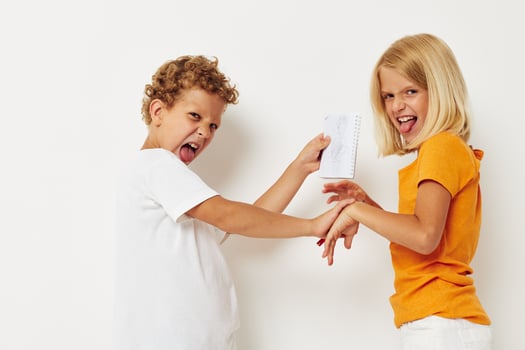 Cheerful boy and girl stand side by side posing light background photo