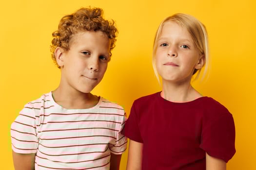 Cute stylish kids cuddling fashion childhood entertainment on colored background photo