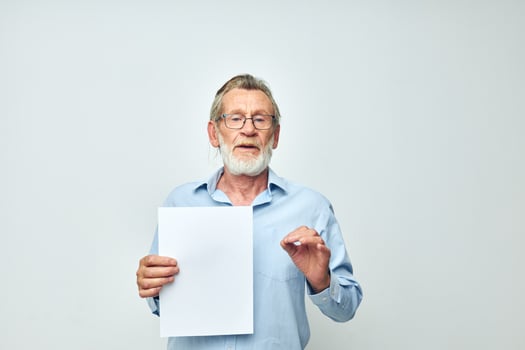 elderly man holding a sheet of paper copy-space posing isolated background photo