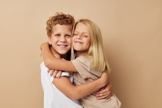 boy and girl in t-shirts hugs beige background friendship photo