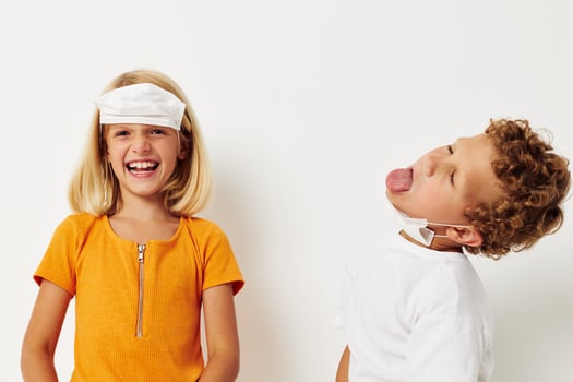 Portrait of cute children fun medical mask stand side by side close-up lifestyle unaltered photo