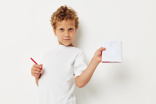 Boy draws with pencil in notebook entertainment studio photo