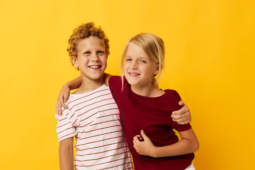 Portrait of cute children cuddling fashion childhood entertainment on colored background photo