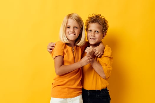 Cute preschool kids casual wear games fun together posing on colored background photo