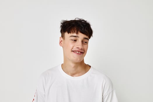 handsome guy tattoo on hands in white t-shirt light background unaltered photo