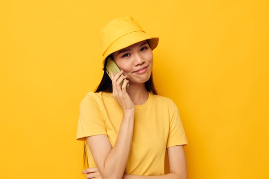 Charming young Asian woman talking on the phone posing fashion isolated background unaltered photo
