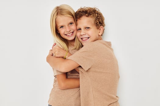 Portrait of cute children in beige t-shirts posing for fun isolated background photo