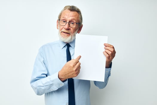 Portrait of happy senior man in a shirt with a tie copy-space sheet of paper cropped view photo
