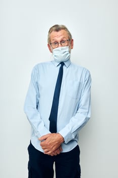 Photo of retired old man in shirt with tie medical mask safety light background