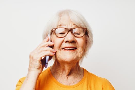 smiling elderly woman in casual t-shirt sunglasses talking on the phone cropped view photo