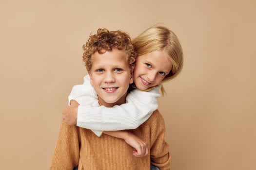 Portrait of cute children hug entertainment posing friendship beige background photo