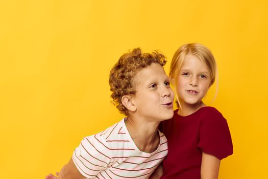 Cute stylish kids cuddling fashion childhood entertainment on colored background photo