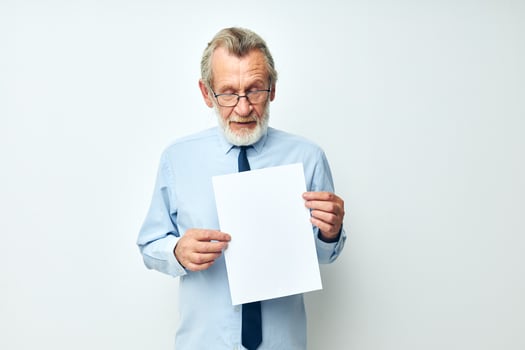 Photo of retired old man holding documents with a sheet of paper light background