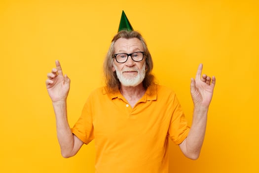Portrait elderly man fun birthday cap on the head isolated background photo