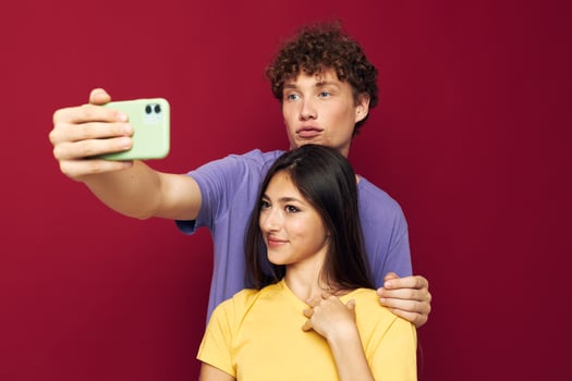 a young couple in colorful T-shirts with a phone Youth style photo