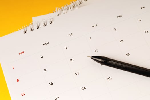 calendar month schedule to make appointment meeting or manage timetable each day lay and pen on yellow background for planning work and travel concept. photo