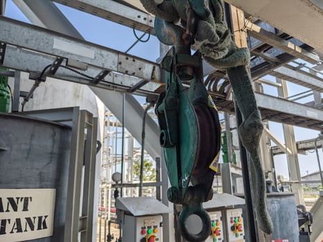 Small pulley on wire robe for lifting material on power plant project. The photo is suitable to use for industrial background and construction content media.