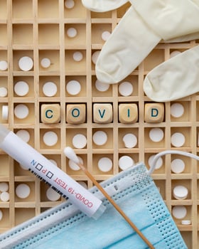 covid-19 testing kits and medical gloves on a wooden board photo
