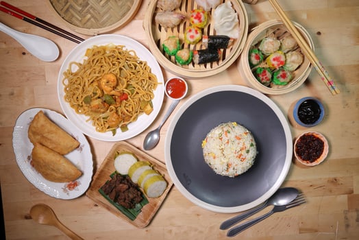 Dumplings dim sum bamboo steamer egg fried rice pulut lemang beef rendang stair fried tofu shrimp noodles chili oil dark soya sauce chpstick fork spoon on wooden table variety cuisine snack fast food photo
