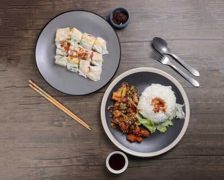 Chinese style Kung Pao Gong Bao Kung Po stair fried chicken and rice noodle roll cheung fun stuffed shrimp chicken vegetable on dark plate sauce fork spoon chopsticks on rustic dark wood table photo