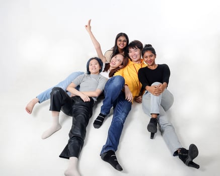 Group of young south east asian mixed race man woman chinese malay indian sit lying pose on floor enjoy relax fun talk gather pose students colleagues look at camera photo