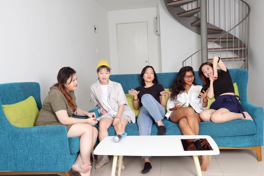 Young Asian woman group talk gossip chat sing party fun enjoy on blue living room sofa photo