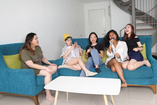 Young Asian woman group talk gossip chat sing party fun enjoy emotion on blue living room sofa photo