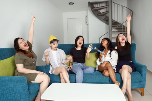 Young Asian woman group talk gossip chat sing party fun enjoy emotion on blue living room sofa photo