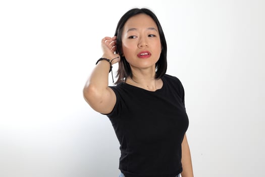 Young attractive south east asian woman pose face expression emotion on white background hand in hair photo