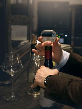 The sommelier opens a bottle of red vintage wine. Close up. photo