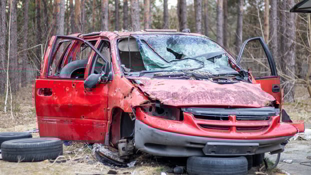 Rusty and broken red abandoned car on the city street. Abandoned old car accident outdoors. Old abandoned rusty car without wheels on the side of the road. photo