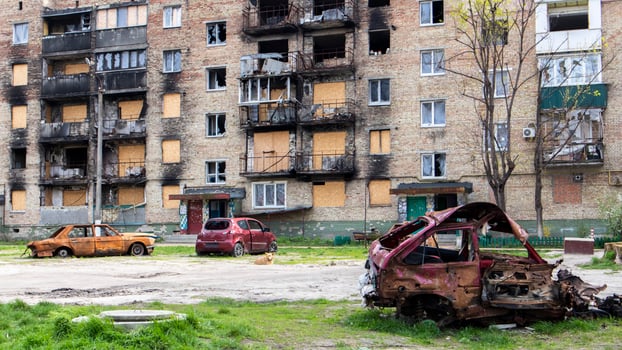 A broken Ukrainian civilian car, shot by artillery, stands in the courtyard of a destroyed house. War between Russia and Ukraine. The wreckage of an abandoned car. photo