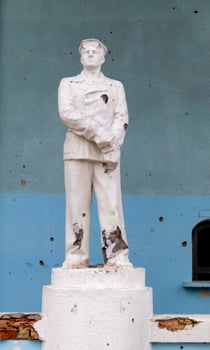 The monument to the Soviet metallurgist was damaged by shelling. A statue battered by rocket fragments stands at the bombed-out cultural center. War in Ukraine. Ukraine, Irpin - May 06, 2023. photo
