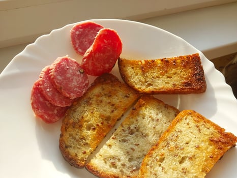 Fried croutons with sausage on a plate photo