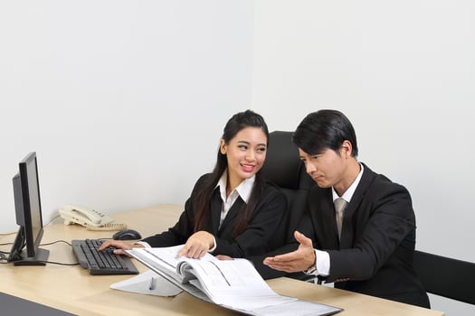 Young Asian male female wearing suit sitting at office desk thinking meeting disucsing sign document agreement photo