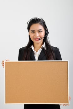 Young Asian female wearing suit sitting at office desk look at camera headphone call center photo