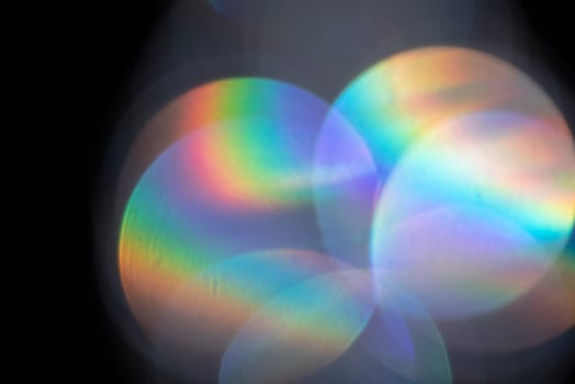 Lens flare, abstract bokeh lights. Reflection from glass or jewelry. Defocused shining colorful spots. Optical iridescent lens effect. photo