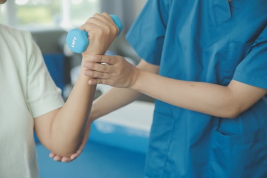 Physiotherapist man giving exercise with dumbbell treatment About Arm and Shoulder of athlete male patient Physical therapy concept photo
