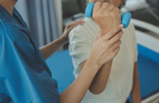 Physiotherapist man giving exercise with dumbbell treatment About Arm and Shoulder of athlete male patient Physical therapy concept photo