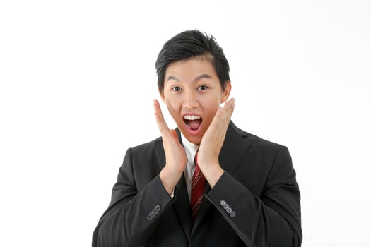 South East Asian young Chinese man wearing formal business office ware on white pose surprised look at camera hand on cheek photo
