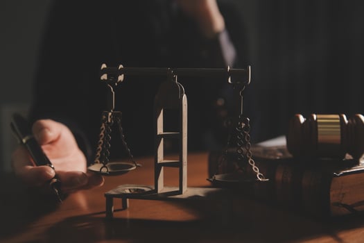 law books and scales of justice on desk in library of law firm. jurisprudence legal education concept. photo