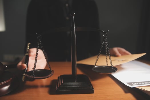 law books and scales of justice on desk in library of law firm. jurisprudence legal education concept. photo