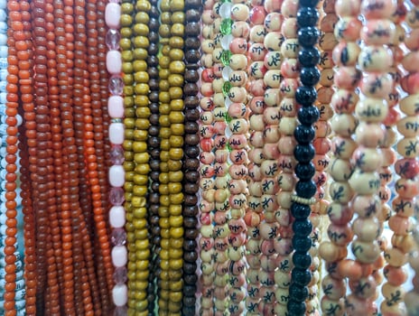 Religious beads with colorful strings. Muslim prayer chaplet market close up shot. Colorful plastic rosaries in the market. Beautiful Muslim prayer beads close up view. Islamic rosary market. photo