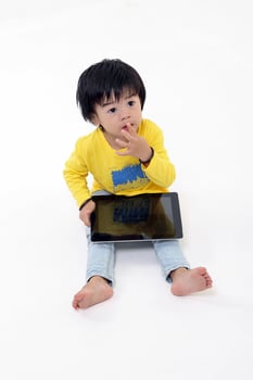 South East Asian young boy child playing tablet tab computer pc on white background photo
