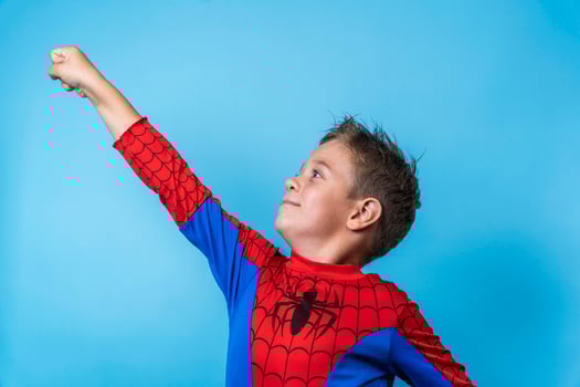 a boy in a hero costume. a victorious upward movement of the hand photo