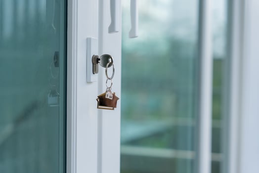 Landlord key for unlocking house is plugged into the door. Second hand house for rent and sale. keychain is blowing in the wind. mortgage for new home, buy, sell, renovate, investment, owner, estate photo