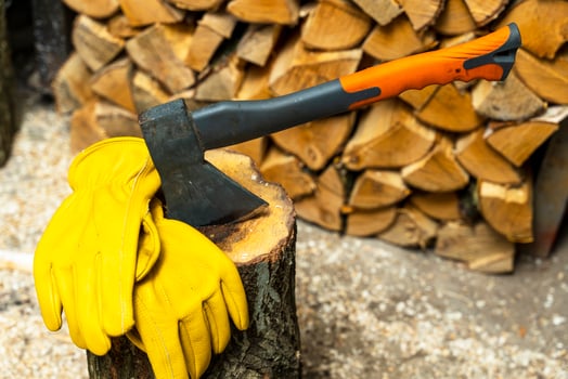 axe stuck in a wooden deck and protective yellow leather gloves photo