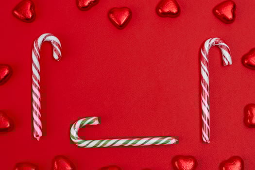 red festive Christmas background with candy in the shape of hearts photo