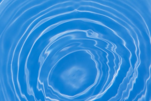 Blue water with ripples on the surface. Defocus blurred transparent blue colored clear calm water surface texture with splashes and bubbles. Water waves with shining pattern texture background. photo