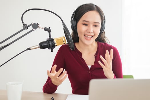 Beautiful asian young woman radio host working in headphones, microphone while talk, conversation and recording podcast, live on social media.Technology of on-air online in broadcasting at studio. photo